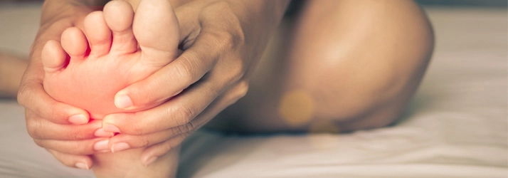 Chiropractic Waukee IA Foot A person holding their foot in pain.