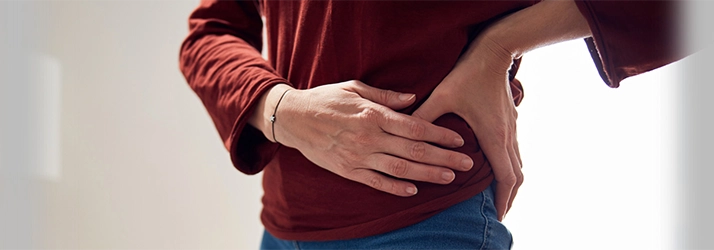 Chiropractic Waukee IA Hip Pain A person holding their hip in pain.
