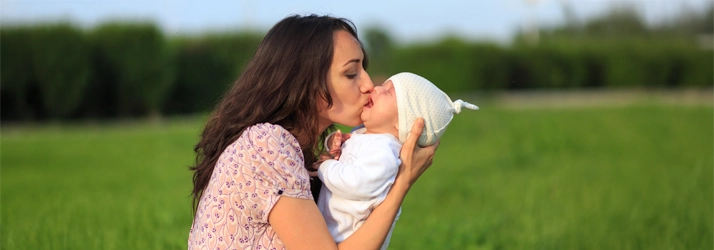Chiropractic Waukee IA Mom And Baby Outside A new mom holding her baby outside.