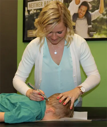 Chiropractor Kelsey Pettitt with a young patient.