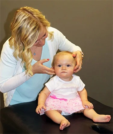 Chiropractor Kelsey Pettitt with a baby.