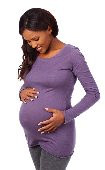 Pregnant woman holding her belly in a purple shirt.